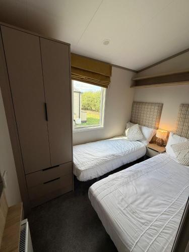 a bedroom with two beds and a window at Parkside Retreats in Kirby Misperton
