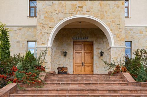a stone house with a wooden door and stairs at Agarani Estate in Telavi