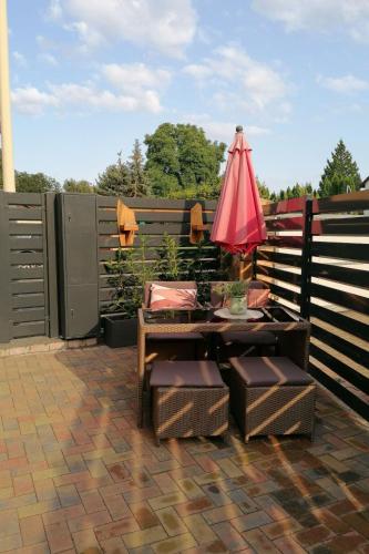 a patio with a table and a red umbrella at Apartment Fewo Wilhelm by Interhome in Scholis