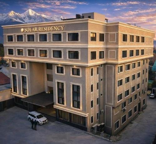 a building with a car parked in front of it at Solar Residency, Srinagar in Srinagar