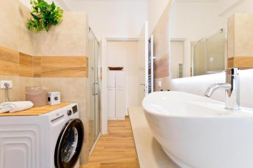 a white bathroom with a washing machine and a sink at Amor Luxury Home in Pescara
