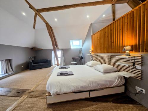 a bedroom with a large bed with a wooden headboard at Gite De L'Aeti - Bail Partner in Chablis