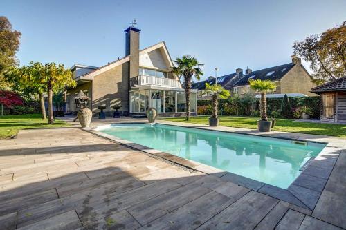 a swimming pool in front of a house at B&B Tuinhuis Vianen in Vianen