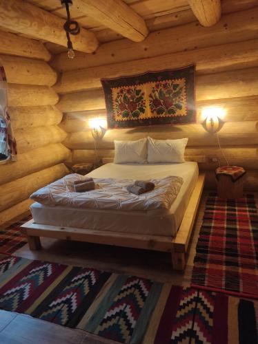 a bedroom with a bed in a log cabin at Rustic House in Predeal
