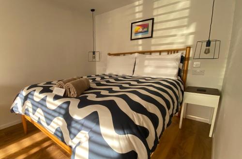 a bedroom with a black and white striped bed at East Cliff Folkestone Guest Suite With Own Entrance in Folkestone