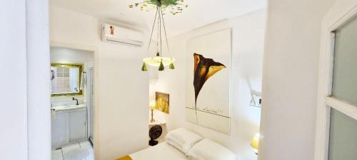 a living room with a white couch and a chandelier at COPSE0102 - Edifício Themis in Salvador
