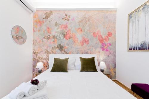 a bedroom with a white bed and a floral wall at Amor Luxury Home in Pescara