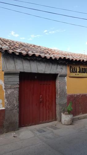 an old building with a red door in front at Casa Jardin in Ayacucho