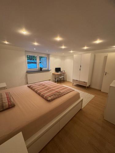 a large bedroom with a large bed and a desk at Schöne Wohnung an einer Pferdeweide in Borstel