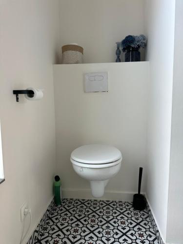 a bathroom with a white toilet and a black and white floor at Luik city center in Liège