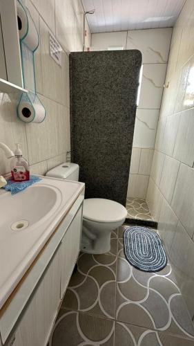 a bathroom with a white toilet and a sink at Suites da Bela 06 Caparao in Caparaó Velho