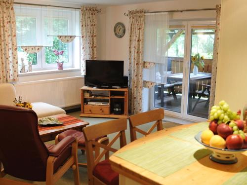 a living room with a television and a table with a bowl of fruit at Apartment Wiesengrund by Interhome in Neuhaus am Rennweg