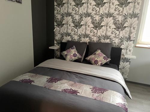a bedroom with a bed with a floral wallpaper at Studio 3 étoiles avec grand JACUZZI PRIVÉ in Horbourg