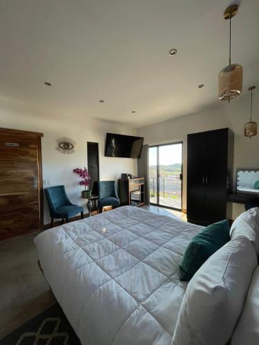 a bedroom with a large white bed and a living room at TEMEXKAL RESORT in Ensenada