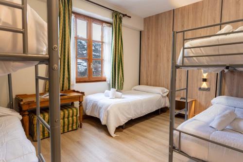 a bedroom with two bunk beds and a window at Hotel Hipic in Vielha