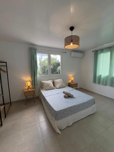 a bedroom with a bed and two lamps and a window at Villa Altura in Rivière-Salée