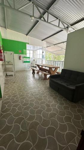 a living room with a couch and a table at Hospedagem da Bela Quarto 7 Banheiro compartilhado in Caparaó Velho