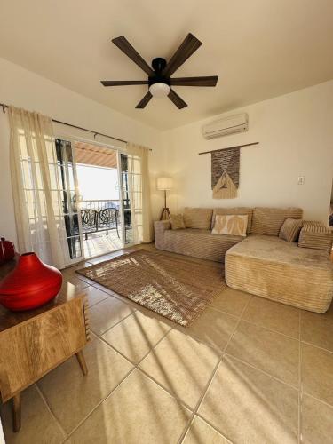 a living room with a couch and a ceiling fan at Bed and Cactus - Ocean View Villa in El Sargento
