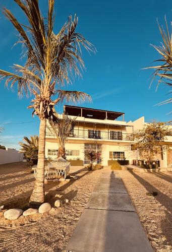 a building with two palm trees and a sidewalk at Bed and Cactus - Ocean View Villa in El Sargento
