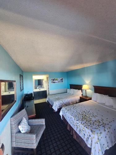 a hotel room with two beds and a chair at Hawk's Nest Lodge in Osage Beach