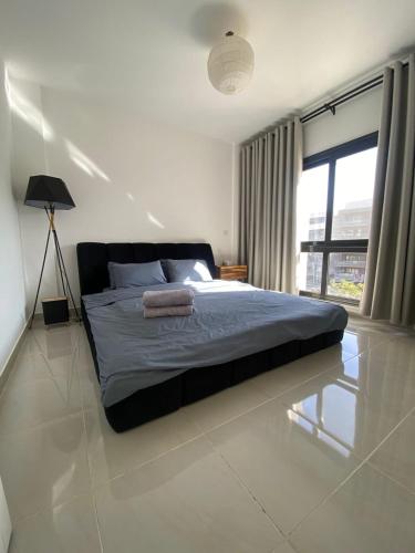 a bedroom with a bed and a large window at loved modern home 2BR in New cairo