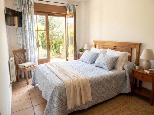 a bedroom with a bed and a sliding glass door at Villa Luisa Apartment in Somo