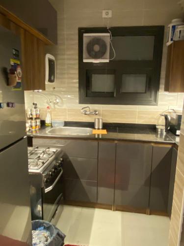a small kitchen with a sink and a stove at loved modern home 2BR in New cairo
