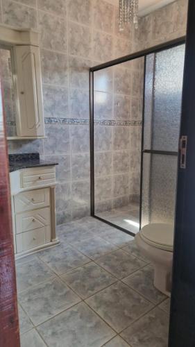 a bathroom with a shower and a toilet at Pousada Ju Haus in Navegantes