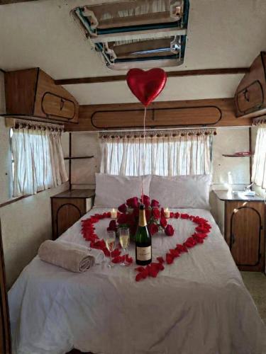 a heart made out of roses and a bottle of wine on a bed at DSC Family Fun Park in Standerton