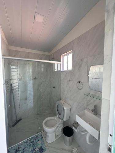 a bathroom with a shower and a toilet and a sink at Mar e Sol Tabatinga in Nísia Floresta