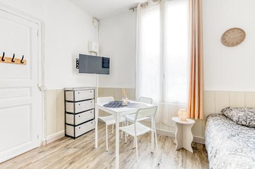 a bedroom with a table and chairs and a bed at Le Signature Studio in Dreux