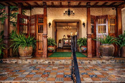 a living room with potted plants in a room at Los Robles Charming Colonial Boutique Hotel in Managua