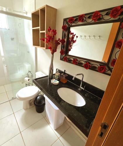 a bathroom with a sink and a toilet and a mirror at SaltBeach Salinópolis Salt Reserve in Salinópolis