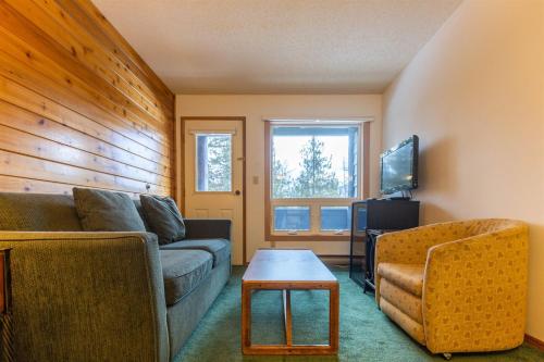 a living room with a couch and a table at Griz Inn by Fernie Central Reservations - Right on The Slopes in Fernie