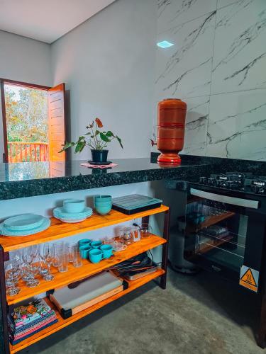 a kitchen with a counter with glasses on a shelf at Chalés Refúgio da Sil in Cavalcante