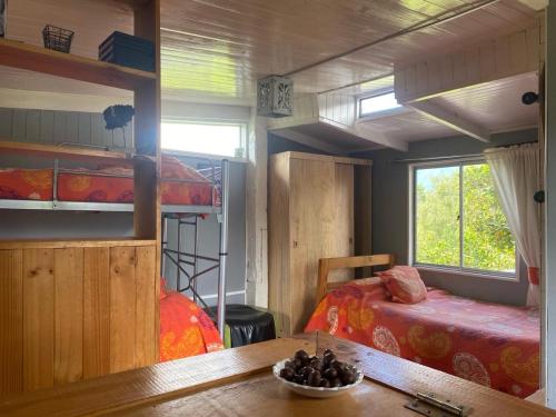 a bedroom with two bunk beds and a table at Natures Balcony Reclaimed Wood Cabin with Villarrica Volcano and Majestic Peak Views in Pucón