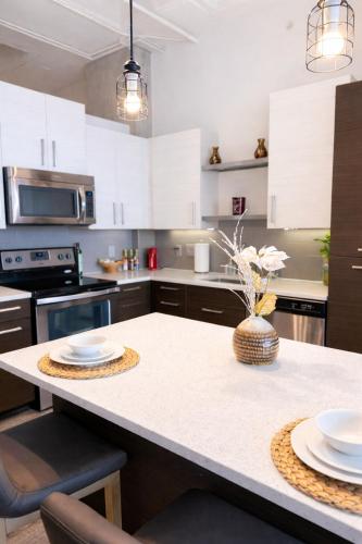 a kitchen with white cabinets and a table with plates on it at Ember Highrise Midtown in Atlanta
