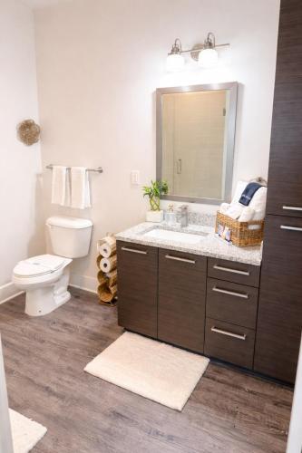 a bathroom with a sink and a toilet and a mirror at Ember Highrise Midtown in Atlanta