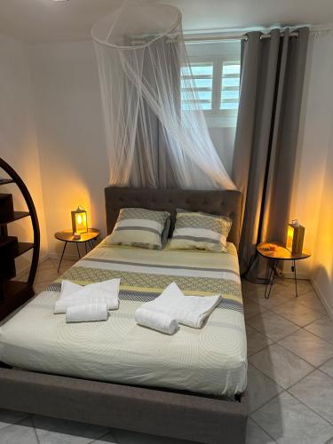 a bedroom with a bed with white pillows on it at Maryvent Apartment in Sainte-Anne