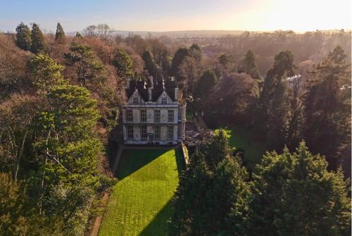 an aerial view of a castle in the trees at The Hall Estate - Historic Grade I-listed Jacobean Mansion in Bradford on Avon