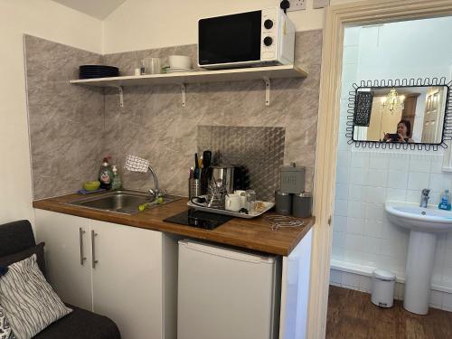 a small kitchen with a sink and a microwave at Station Approach Solihull Cabin Stays in Solihull