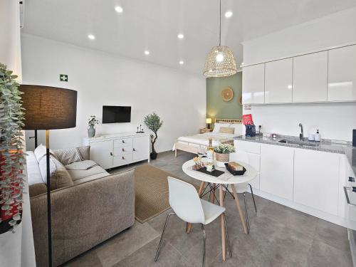 a kitchen and living room with a couch and a table at MF Terceira - Superior Boutique Suite in Praia da Vitória