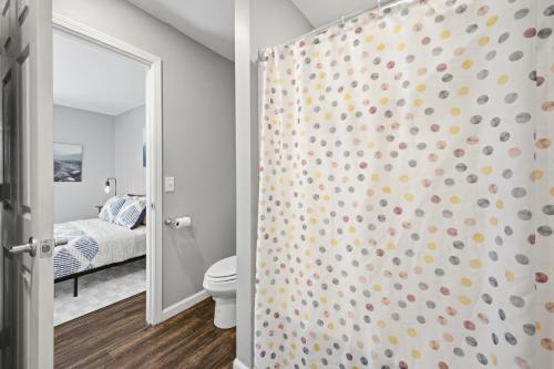 a bathroom with a shower with a toilet and a bedroom at Sun Valley Loft, Close to Mosaic! in Saint Joseph