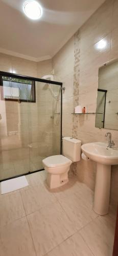 a bathroom with a toilet and a sink and a shower at Pousada Mirante Do Lago in Lindóia