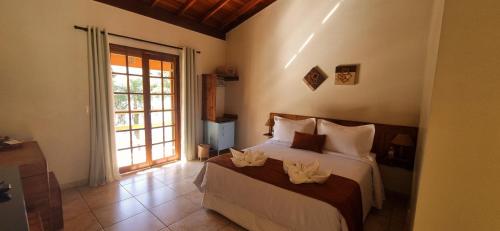 a bedroom with a bed with two candles on it at Pousada Mirante Do Lago in Lindóia
