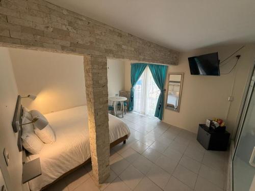 a bedroom with a large bed with a stone wall at Victoria Hotel y Spa in Ixtapan de la Sal