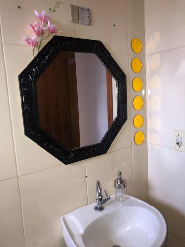 a bathroom with a sink and a mirror on the wall at Casa para diarias e empresas in Cianorte