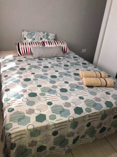 a bed in a bedroom with a green and white comforter at Casa para diarias e empresas in Cianorte