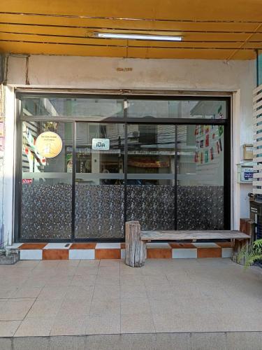 a store front window with a bench in front of it at เส้นดี โฮสเทล Sendee Hostel in Phitsanulok