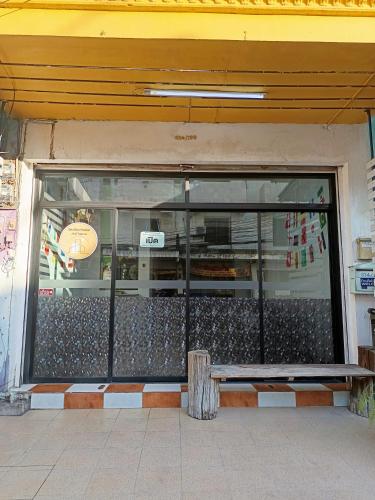 a store front with a bench in front of a window at เส้นดี โฮสเทล Sendee Hostel in Phitsanulok